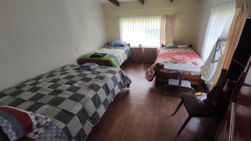 a room with two twin beds and a window at San Silvestre de Irupana in Chulumani