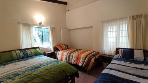 a bedroom with two beds and a window at San Silvestre de Irupana in Chulumani