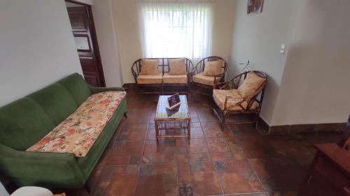 a living room with couches and chairs and a table at San Silvestre de Irupana in Chulumani