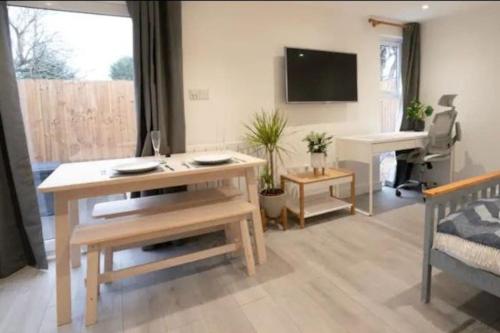a living room with a table and a piano at Luxury cabin with hot-tub in Cheltenham