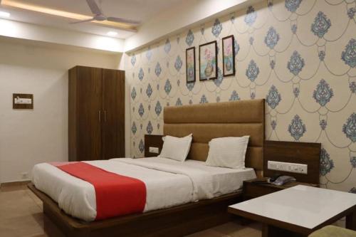 a bedroom with a bed with a red and white blanket at Hotel Legend in Modāsa
