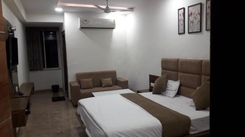 a bedroom with a large bed and a couch at Hotel Legend in Modāsa