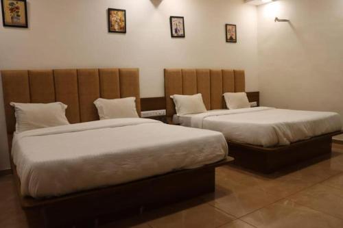 two beds in a room with two beds sidx sidx at Hotel Legend in Modāsa
