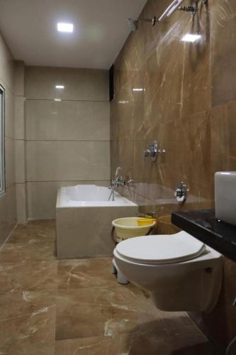 a bathroom with a toilet and a bath tub at Hotel Legend in Modāsa
