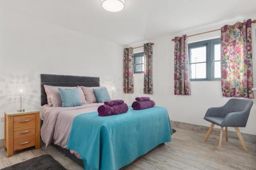a bedroom with a bed with purple stuffed animals on it at Ramsey Sea View Cottage - Dog Friendly in Pembrokeshire