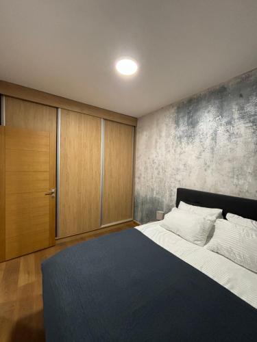 a bedroom with a large bed and a wooden cabinet at Tenea Apartment & SPA in Zlatibor