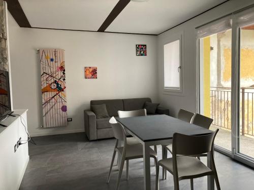 Residence La Corte di San Rocco في Cremeno: غرفة معيشة مع طاولة وكراسي وأريكة