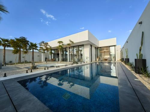 una vista exterior de una casa con piscina en منتجع LA, en Al Wudayy