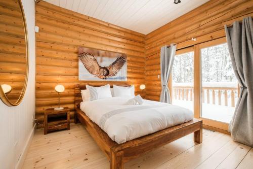um quarto com uma cama num quarto de madeira em Chalet Golden Bear - Fiddler Lake em Mille-Isles