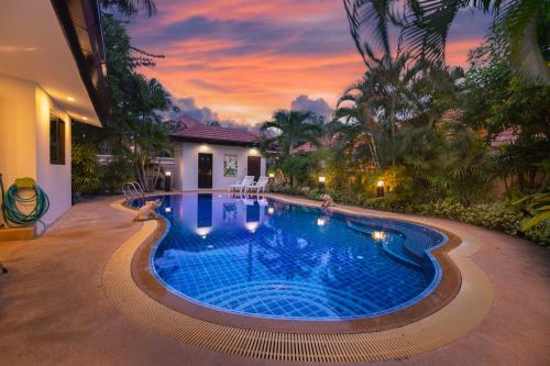uma piscina num quintal com um pôr-do-sol em Baan Leelawadee - 4 Bed Villa near Beach Pattaya em Nong Prue