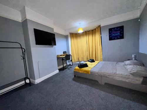 een slaapkamer met een bed, een bureau en een televisie bij Students Contractors Professionals in Leicester
