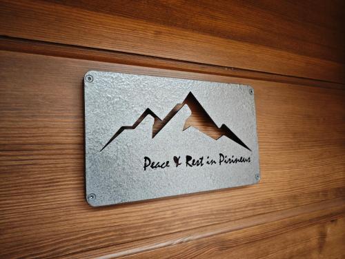 una placa de metal en una puerta de madera con una señal de montaña en Peace & Rest in Pirineus en Latour-de-Carol