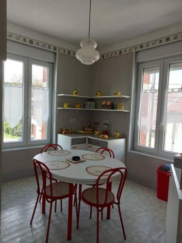 a kitchen with a table and chairs in a room at F2 1ER ETAGE - 5 min du Lac de Madine in Vigneulles-lès-Hattonchâtel