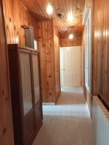 a hallway of a home with a door and wooden walls at F2 1ER ETAGE - 5 min du Lac de Madine in Vigneulles-lès-Hattonchâtel