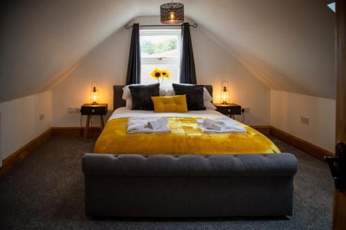 a bedroom with a bed with a yellow comforter and a window at Oak House - sleeps 10 with Bar & Games room in Reighton