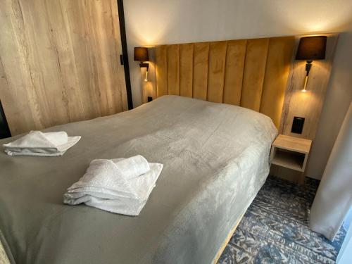 a bedroom with a bed with two towels on it at Złoty Horyzont Spa 1 in Szklarska Poręba