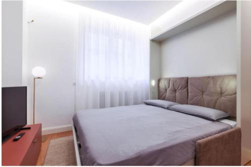 a bedroom with a bed and a dresser and a window at Porta Nuova Apartment in Milan