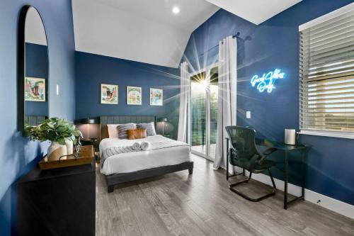 um quarto azul com uma cama e uma secretária em Downtown Gateway: Stylish Nest Near Austin Airport em Austin