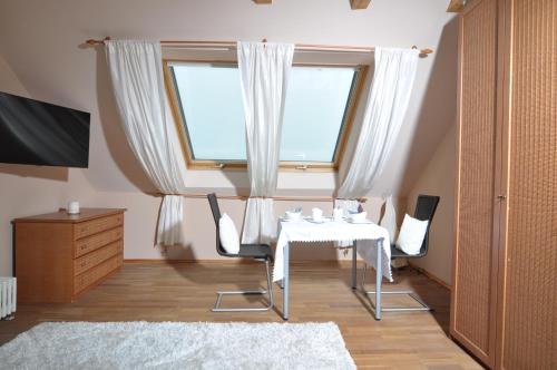 ein Esszimmer mit einem Tisch, Stühlen und einem Fenster in der Unterkunft Evis Cottage in Wertheim