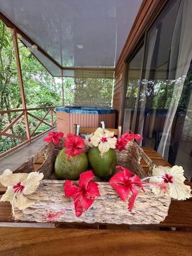a table with fruits and flowers on top of it at CABAÑAS DEL LAGO / BUNGALOWS in San Ramón