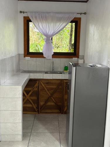 a kitchen with a sink and a window at CABAÑAS DEL LAGO / BUNGALOWS in San Ramón