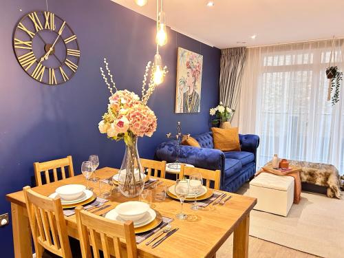 a dining room with a table and a clock on the wall at Modern 2 King BR Apartment with Gym, Rooftop in London