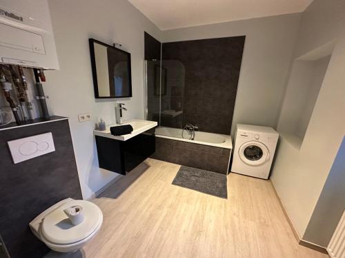 a bathroom with a sink and a washing machine at LFA Charmante maison de ville in Flémalle-Grande