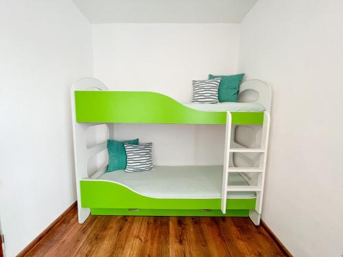 a green and white bunk bed in a room at Chata pri jazere Nitrianske Rudno in Nitrianske Rudno