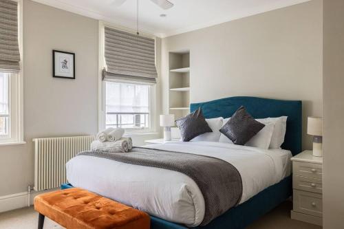 a bedroom with a large bed with a blue headboard at A Grand Four Bedroom Townhouse at Knightsbridge in London