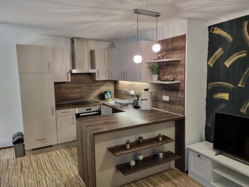 a kitchen with white cabinets and a wooden counter top at Haus am Soleweg in Ebensee