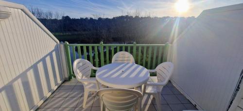 a table and chairs on a balcony with the sun at Appartement T2 à Port-Bourgenay Résidence île au pré in Talmont