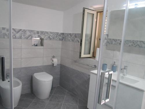 La salle de bains est pourvue de toilettes, d'un lavabo et d'un miroir. dans l'établissement VistaMare, à Realmonte