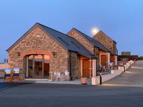 a building with tables and chairs outside of it at Ramsey Sea View Cottage - Dog Friendly in Pembrokeshire