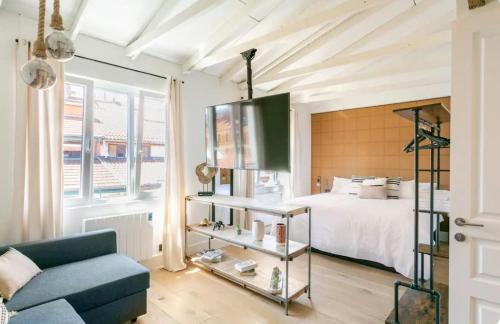 1 dormitorio con 1 cama y 1 sofá azul en Good Vibe Rooms, en Bilbao