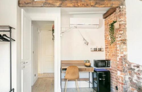 a kitchen with a wooden table and a brick wall at Good Vibe Rooms in Bilbao