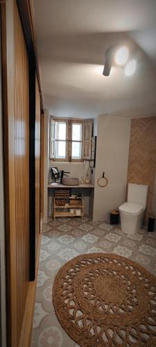a bathroom with a toilet and a rug on the floor at El 6 De Busquet in Cáceres