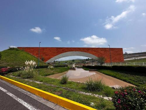 Casa entera Morelia, hospitales, corporativos 2 في موريليا: جسر فوق طريق بجانب جدار من الطوب