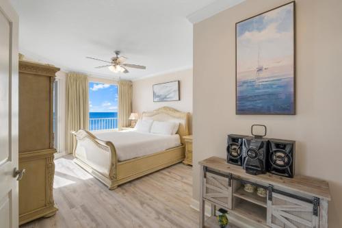 1 dormitorio con 1 cama y mesa con TV en Marisol 401 - Coastal Serenity, en Panama City Beach