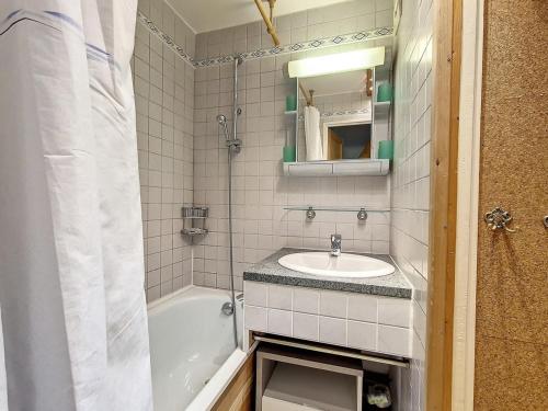 une salle de bain avec un lavabo et une baignoire et un lavabo dans l'établissement Charmant Appartement avec Mezzanine, Balcon et Garage Privé - Proche des Pistes - FR-1-344-1064, aux Menuires