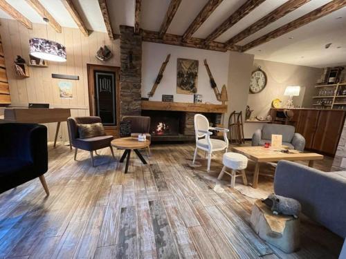 a living room filled with furniture and a fireplace at Hôtel La Rencluse in Luchon