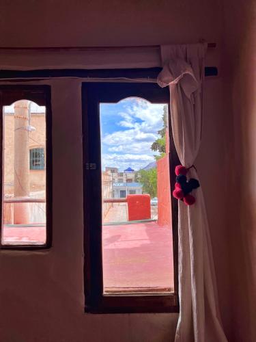 uma janela com uma cortina e uma vista em CerroNegro em Tilcara