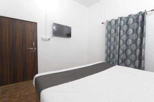 una camera con letto e TV a parete di Chitraa guest house a Prayagraj