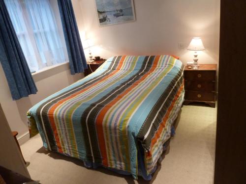 ein Schlafzimmer mit einem Bett mit einer bunten Decke in der Unterkunft Spacious in Croxley Green