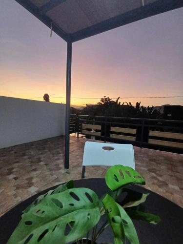 a room with a table and a white chair and the sunset at BMF Homestay Jacuzzi in Tacloban