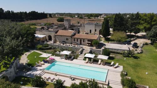 an aerial view of a house with a swimming pool at Masseria San Cosimo in Carpignano Salentino