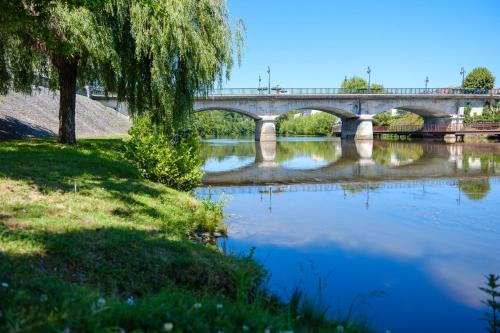 a bridge over a river with a bridge in the background at Le Maleville - Appartements de Standing in Périgueux