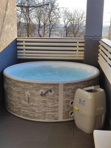 a hot tub on the balcony of a building at Mjesto za odmor Golden Hill in Šandrovac