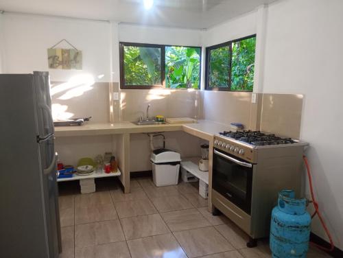 a kitchen with a stove and a counter with windows at casa playa negra in Puerto Limón