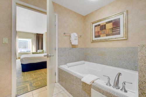 a bathroom with a tub and a bedroom with a bed at Luxury 1BD/1BTH Suite at Platinum Hotel *STRIP VIEW in Las Vegas