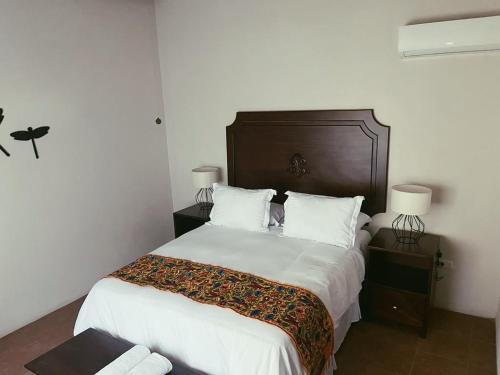 a bedroom with a large bed with white sheets at Hacienda Escondida 10min to Airport in Alajuela City